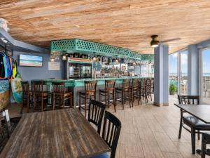 a bar with wooden ceilings and wooden tables and chairs at Ocean East Resort Club in Ormond Beach