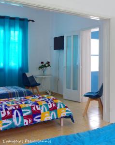 a bedroom with a bed and two chairs and a television at Garden house in Amarynthos