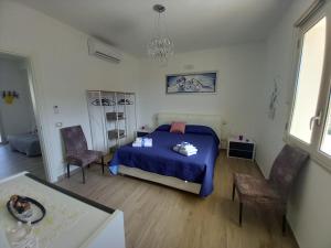 a bedroom with a blue bed and two chairs at il tramonto in Capaci