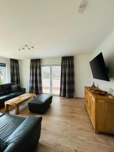 a living room with a couch and a flat screen tv at Ferienhaus Zingel in Eckernförde