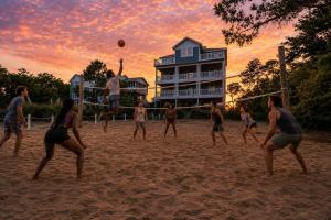 a group of people playing a game of volleyball on the beach at OPM Coastal Retreat in Salvo