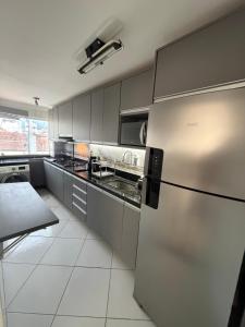 a kitchen with a stainless steel refrigerator and appliances at Premium Feira ap 01 - Ar - Feiraguay - 24H check-in in Feira de Santana