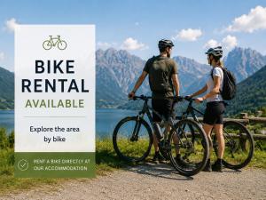 a man and a woman standing next to a bike rental available sign at PAVLIN Bed & Breakfast in Šenturska Gora
