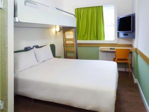 a bedroom with a white bed and a desk at ibis budget Osasco in Osasco