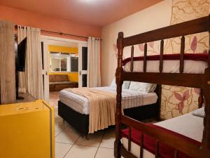 a bedroom with two bunk beds and a living room at Mansão Ouro Verde Beira Mar in Piçarras +46 photos