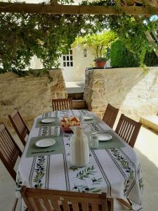 a table with a tablecloth on a table with chairs at Maison Brunetière in Saint-Martin-lʼArs