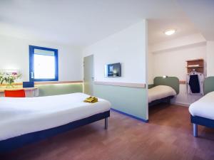 a hotel room with two beds in a room at ibis budget Troyes Est in Saint-Parres-aux-Tertres +92 photos