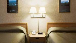 a hotel room with two beds and a clock on a night stand at Magnuson Grand Rushmore View in Keystone +11 photos