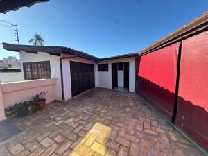 a house with a red and white wall and a patio at Casa Villa Coloniale in Espirito Santo Do Pinhal
