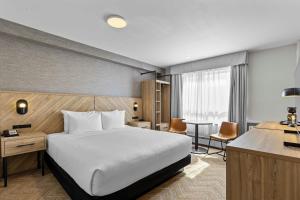 a hotel room with a bed and a desk at Sandman Hotel & Suites Calgary West in Calgary +64 photos