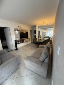a living room with a couch and a dining room at Premium Feira ap 01 - Ar - Feiraguay - 24H check-in in Feira de Santana +17 photos