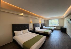 a hotel room with two beds and a window at Hotel Diana del Bosque by DOT Urban in Morelia