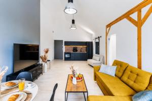 a living room with a yellow couch and a table at Apartment Quiet Street 11/7E in Oświęcim