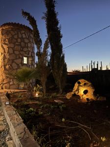 a garden with a fence and trees and a building at Chalet en Pierre Benslimane in Aïn Sferjila