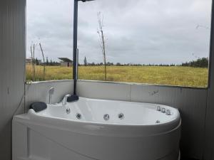 a white bath tub in a room with a window at Chalet en Pierre Benslimane in Aïn Sferjila