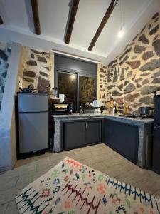 a kitchen with a stone wall and a counter top at Chalet en Pierre Benslimane in Aïn Sferjila