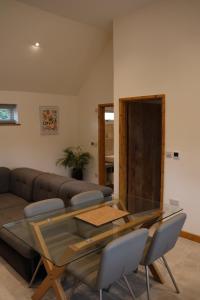 a glass table and chairs in a living room at South Barn in Stanningfield