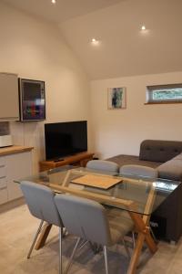a living room with a glass table and a couch at South Barn in Stanningfield
