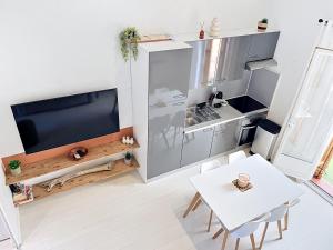 a small kitchen with a refrigerator and a table at Maison village accès mer et commerces à pieds in Le Barcarès