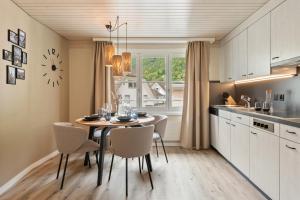 a kitchen and dining room with a table and chairs at Interalps - AlpsView Premium Apartments Altdorf - Free Parking - AC in Altdorf