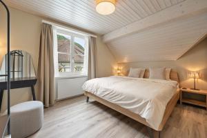 a bedroom with a large bed and a window at Interalps - AlpsView Premium Apartments Altdorf - Free Parking - AC in Altdorf