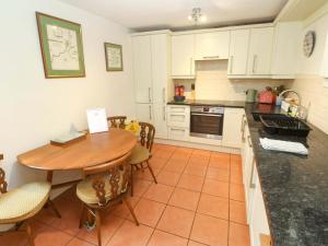 a kitchen with a wooden table and a dining room at May Cottage in Pentewan +22 photos