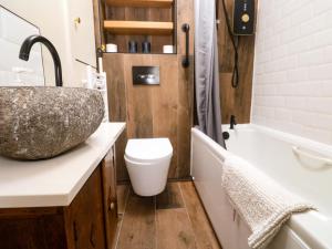 a bathroom with a sink and a toilet and a tub at May Cottage in Pentewan