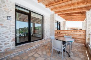 a patio with a table and chairs and windows at Vila Milo in Himare