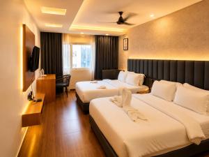 a hotel room with two beds and a television at The Saffron Hotel in Bhubaneshwar +35 photos