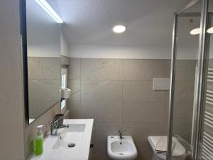 a bathroom with a sink and a toilet and a shower at Chiara 5 in Cairo Montenotte