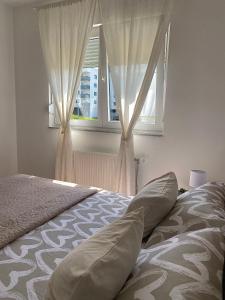 a bedroom with a bed and a window with curtains at Verde Apartment in Banja Luka