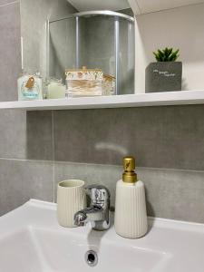 a bathroom sink with a gold faucet on it at Verde Apartment in Banja Luka +10 photos