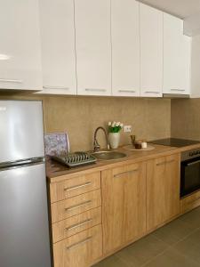 a kitchen with white cabinets and a stainless steel refrigerator at Verde Apartment in Banja Luka
