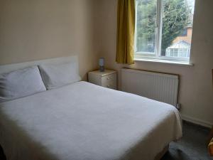 a bedroom with a white bed and a window at Milton Keynes Lettings in Milton Keynes