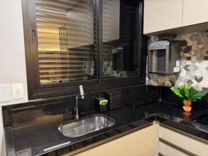 a kitchen counter with a sink and a window at Haven Residence in Uberlândia +25 photos