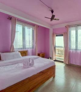 a bedroom with a large bed with purple walls at La Murphy Homestay in Cherrapunji +8 photos