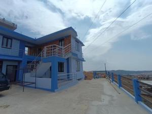a blue house with a balcony on the side of it at La Murphy Homestay in Cherrapunji