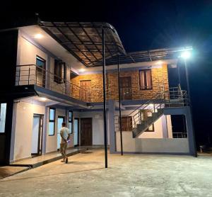 a man standing in front of a house at night at La Murphy Homestay in Cherrapunji