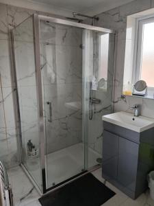 a bathroom with a glass shower and a sink at Milton Keynes Lettings in Milton Keynes
