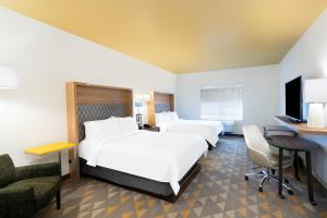a hotel room with two beds and a desk at Holiday Inn Hotels Batesville by IHG in Batesville +16 photos