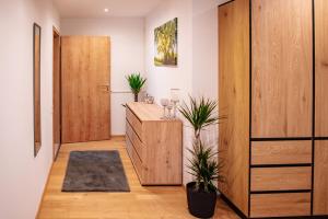 a hallway with a wooden cabinet and two plants at Ferienwohnungen Kreuzer in Regen
