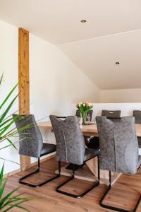 a dining room with a wooden table and chairs at Ferienwohnungen Kreuzer in Regen