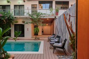 a courtyard with a swimming pool and chairs next to a building at Hotel Fusión in Puerto Escondido