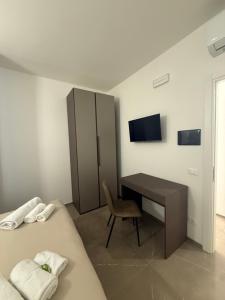 a bedroom with two beds and a desk and a tv at Chiara 2 in Cairo Montenotte