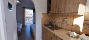 a kitchen with a sink and a living room at Ragias Studios in Tsilivi