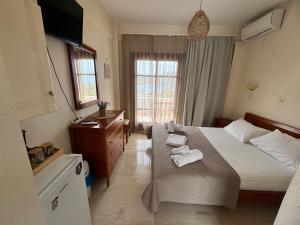 a bedroom with a bed and a dresser with towels on it at Olive Grove in Plakias