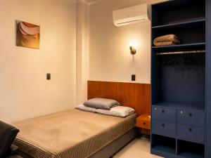 a small bedroom with a bed and a closet at Studio Moderno e Novo - Cozinha Completa, Ar Condicionado e Wifi - Rápido Acesso ao Centro in Chapecó