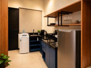 a kitchen with a sink and a refrigerator at Studio Moderno e Novo - Cozinha Completa, Ar Condicionado e Wifi - Rápido Acesso ao Centro in Chapecó