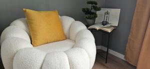 a white chair with a yellow pillow on a table at By The Pool Apartments #10 in Velingrad