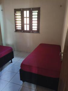 a bedroom with two beds and a window at Chalé Triunfo in Pacoti